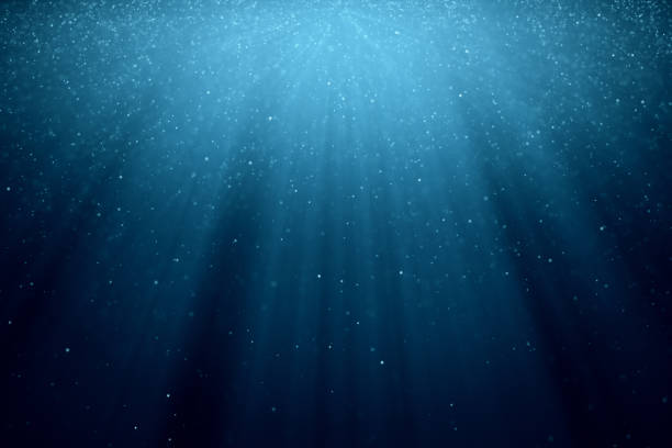 istock Abstract background with motion of shining blinking particles on blue background with rays of light. 3d illustration 1076664604