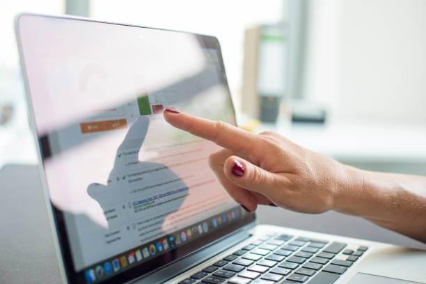 istock Cropped Hand Pointing At Laptop 1076665084
