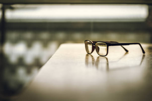 istock Pink classic eye glasses  on wooden table. 1076670890