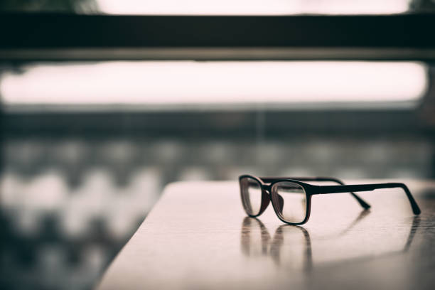 istock Pink classic eye glasses  on wooden table. 1076670972