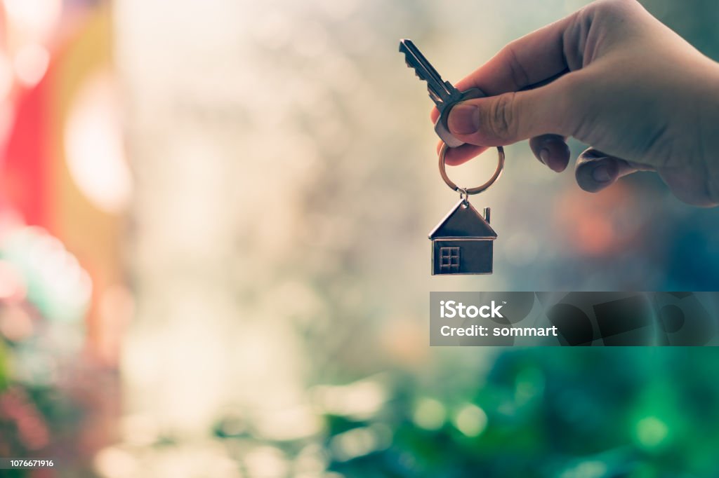 House model and key in home insurance broker agent  hand or in salesman person. Real estate agent offer house, property insurance and security, affordable housing concepts House Stock Photo