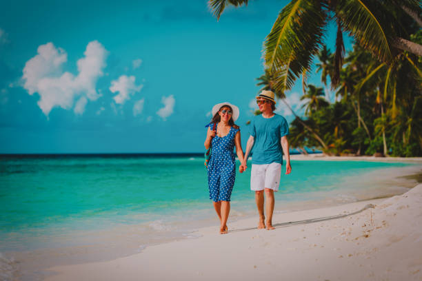 istock happy loving couple walking on tropical beach 1076672274