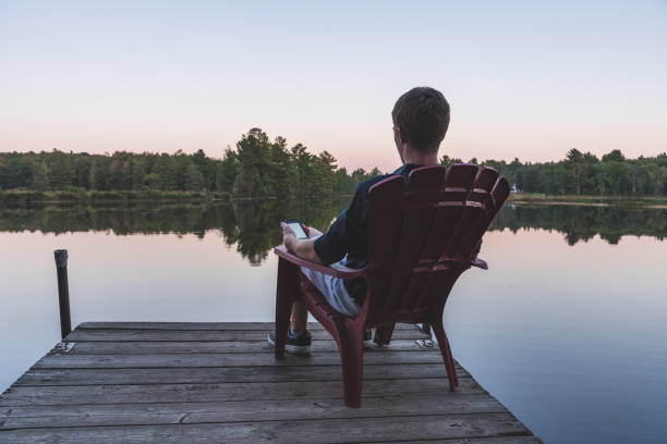istock Young man with a cell phone enjoying the sunset. 1076678080