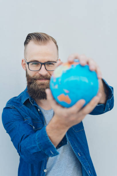 istock Confident young man holding a geographic globe 1076682728