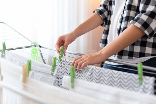 Woman hanging wet clothes to dry stock photo