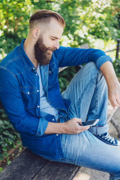 istock Casual attractive man relaxing on a park bench 1076684344