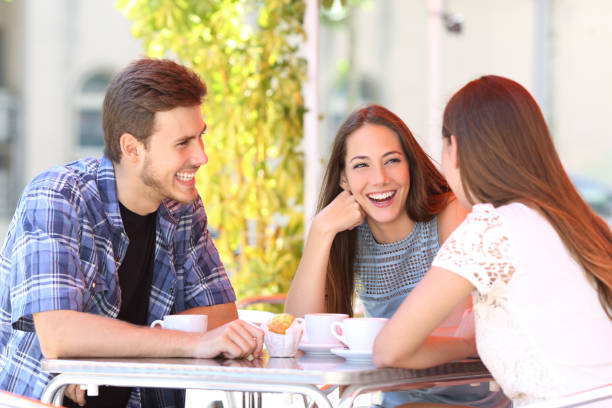 Three happy friends talking in a coffee shop