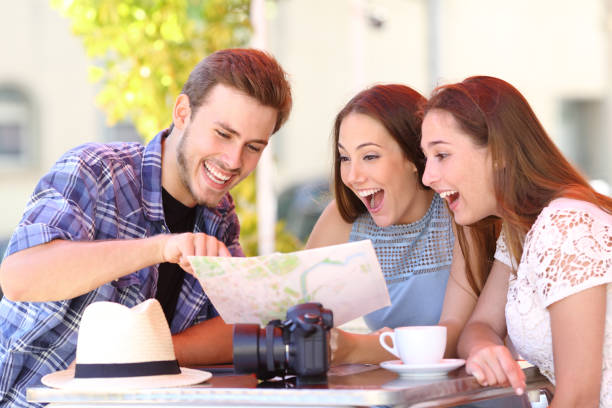 istock Three happy tourists checking guide in a coffee shop 1076684936