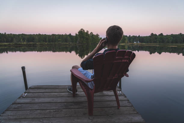 istock Young man with a cell phone enjoying the sunset. 1076688436