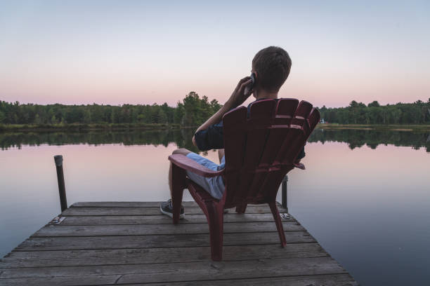 istock Young man with a cell phone enjoying the sunset. 1076688906