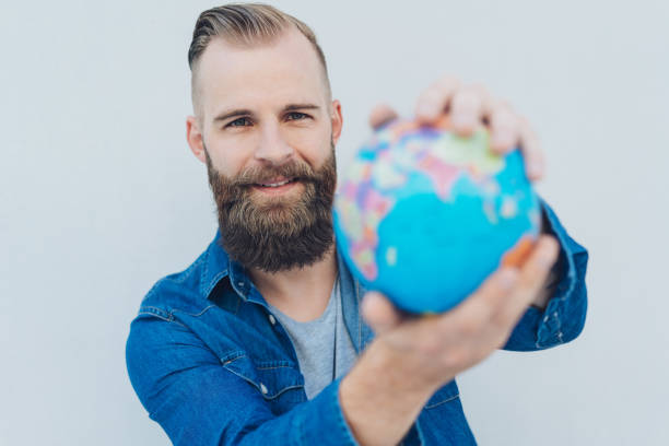 istock Young cheerful bearded man holding globe 1076693904