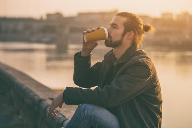 istock Businessman drinking coffee while resting by the river 1076695144