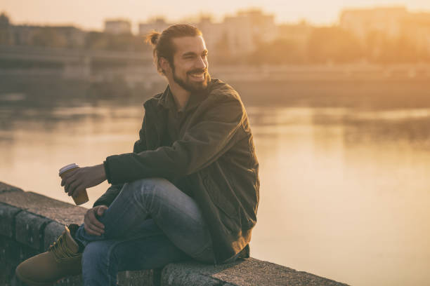 istock Businessman drinking coffee while resting by the river 1076695636