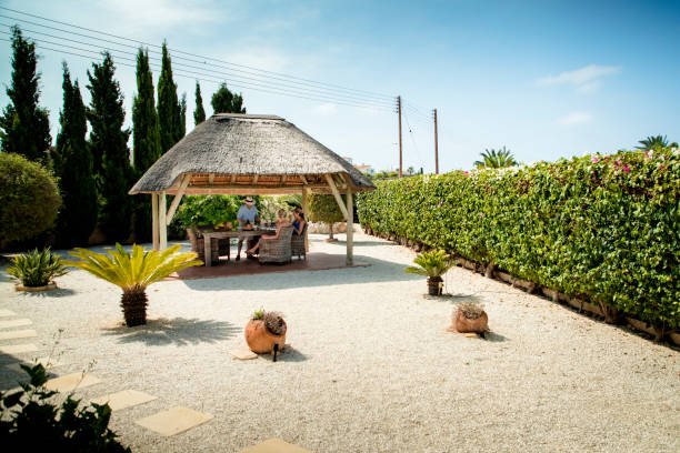 Friends, on holiday, relaxing under the gazebo away from the sun. They're preparing some lunch.