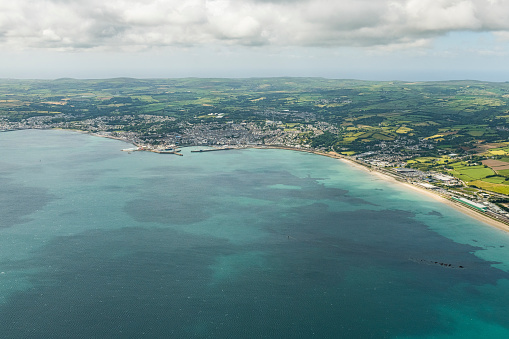 Aerial views over the sea to Penzance, Newlyn and Mousehole, Cornwall on a bright sunny June day.