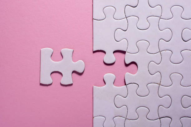 istock Incomplete white jigsaw puzzle pieces on pink background 1076708542