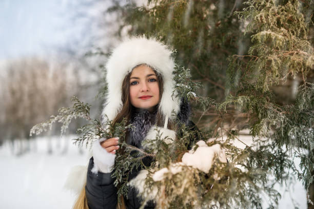 istock Smiling beautiful woman with tree branches in winter park 1076717094