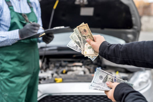 Female hands giving dollar banknotes to mechanic Female hands giving dollar banknotes to mechanic cash for cars stock pictures, royalty-free photos & images