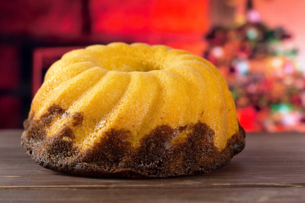Fresh baked marble gugelhupf sweet bread with christmas tree behind