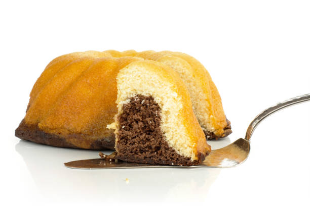 Group of one whole one slice of fresh baked marble gugelhupf sweet bread variety with cake spatula isolated on white background