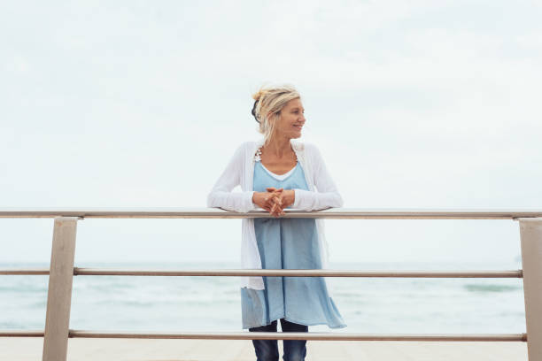 istock Slender trendy blond woman on a waterfront pier 1076725482