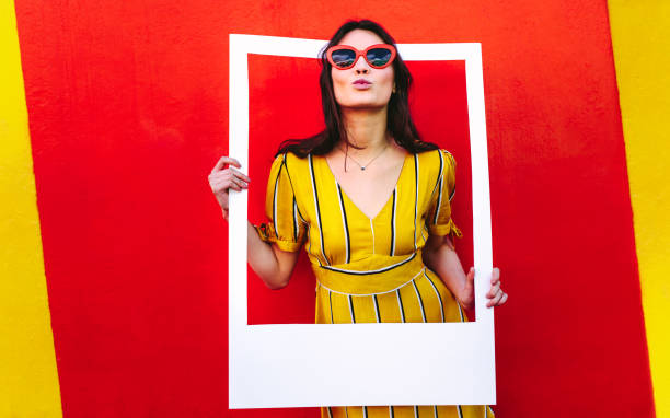 istock Attractive girl posing with photo frame 1076730744