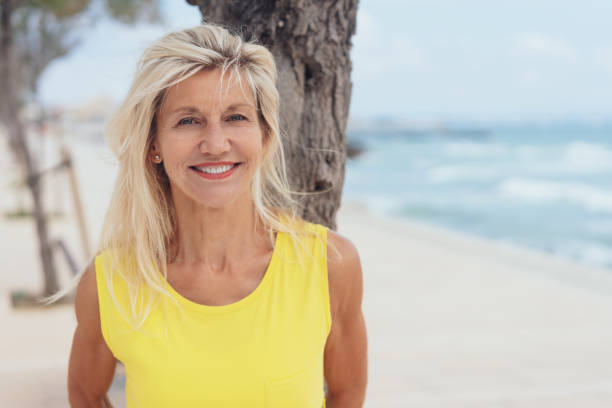 istock Attractive tanned blond woman standing on a beach 1076732304