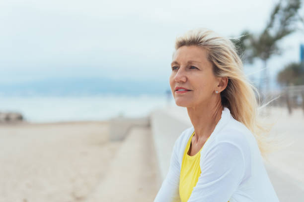 istock Thoughtful older woman on a seafront promenade 1076734590