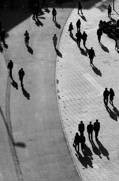 istock people walking at the street with long shadows 1076742550