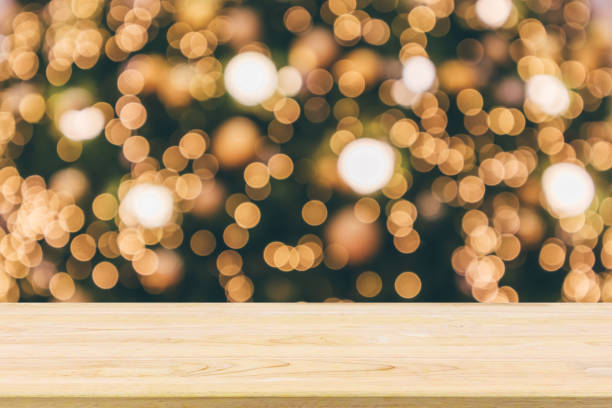 istock Wood table top with abstract christmas holiday festive bokeh light on tree blurred background for montage product display 1076745404