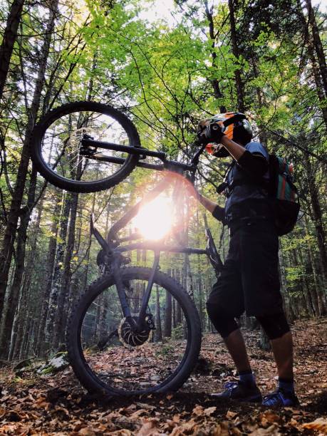 istock Young man mountain biking into the sunset 1076746860