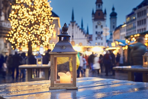 Traditional christmas market in city. Selective focus on lantern with burning candle. Marienplatz in Munich, Germany.