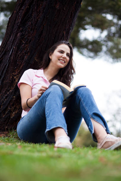 istock Woman reading in the park 1076760332