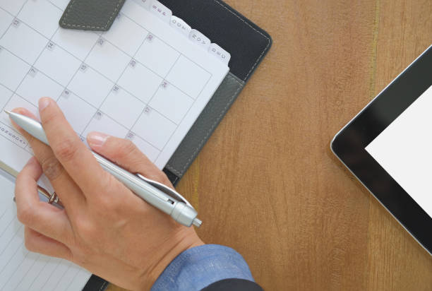 istock hand working with notebook. tablet on wooden desk. office workplace top view 1076762744