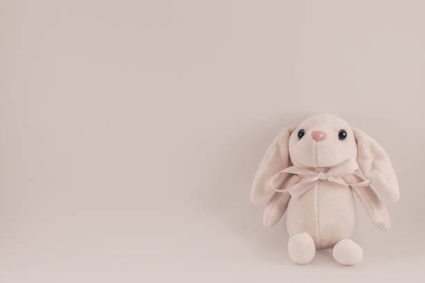 istock postcard with sitting toy white pink rabbit on a white background 1076770646