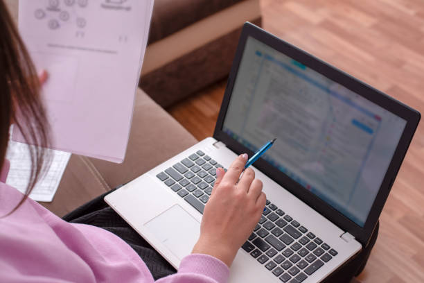 istock Unknown person sitting at a laptop on couch 1076771386