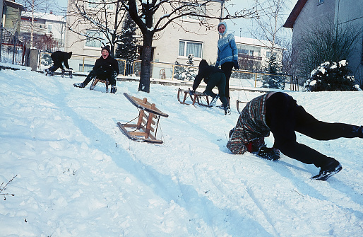 Sinsheim, Germany - Winter 1964: Children have fun while tobogganing in winter. In the mid 1960s, in a small town in South Germany. Federal state of Baden-Wurttemberg. Europe. Digitized slide.