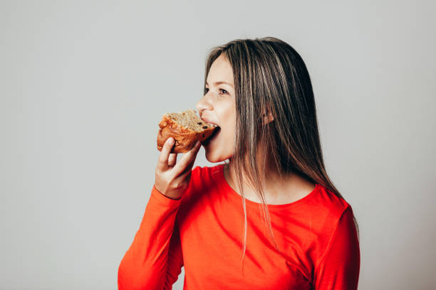 giovane donna brasiliana che mangia panettone. giovane donna che mangia pane. - panettone foto e immagini stock