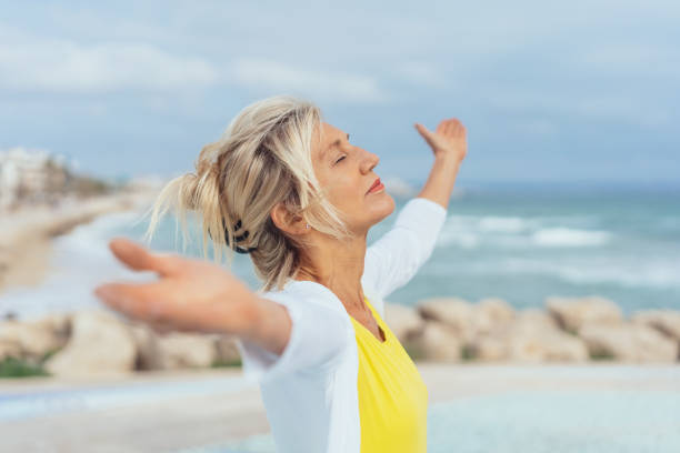 istock Woman standing on a beach meditating 1076783572