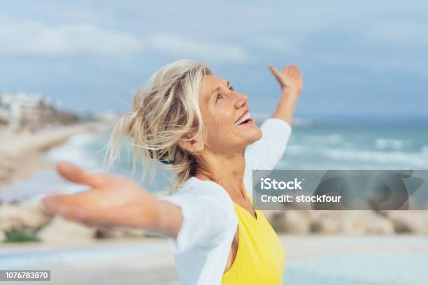 Joyful Woman Enjoying The Freedom Of The Beach Stock Photo - Download Image Now - Women, Happiness, Senior Adult