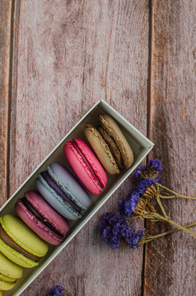 istock French macaroon cake. Macaroons in box with dried flowers on wood background 1076785348