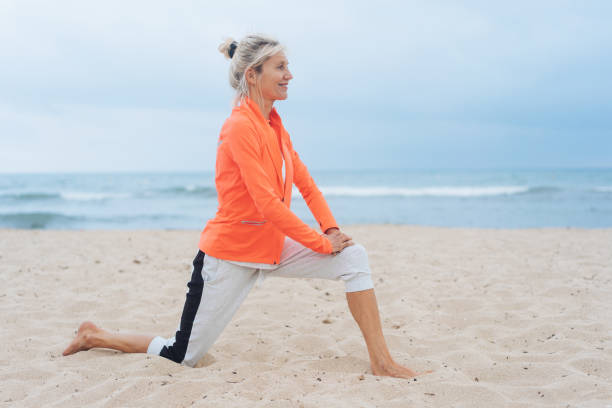 active healthy woman doing stretching exercises - stretch beach imagens e fotografias de stock