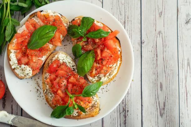 traditionelle geröstete italienische tomaten bruschetta mit gewürz und basilikum auf hölzernen hintergrund. draufsicht vith textfreiraum - bruschetta stock-fotos und bilder