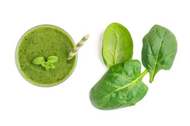 Spinach smoothies. Healthy green juice iwith spinach leaves solated on white background. Top view.