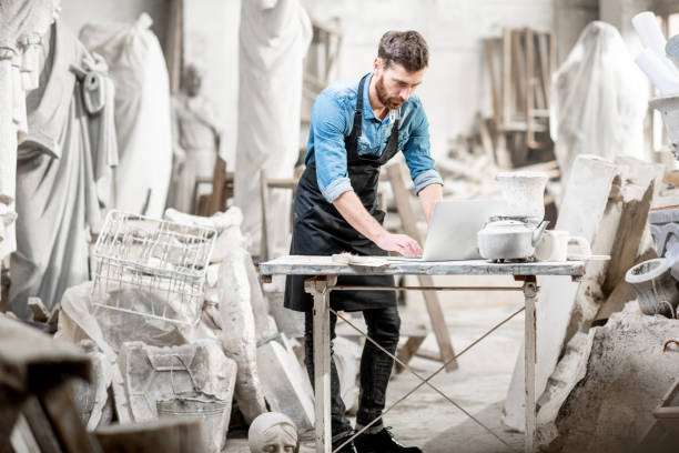 istock Sculptor working with laptop in the studio 1076792564