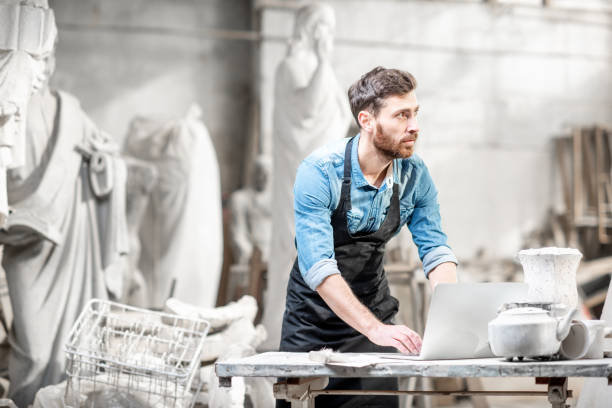 istock Sculptor working with laptop in the studio 1076792688