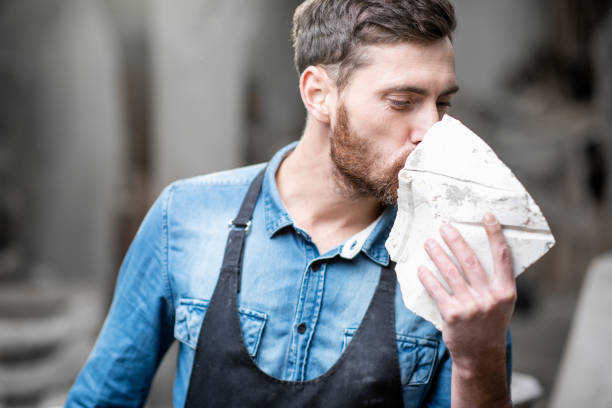 istock Sculptor with a piece of stone in the studio 1076795154