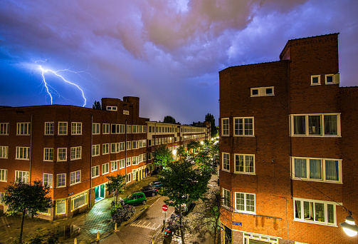 Lightning bolts light up the sky and strike behind a housing building in Amsterdam, the Netherlands.