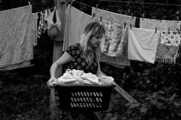 Photo of Woman hangs laundry on a clothesline