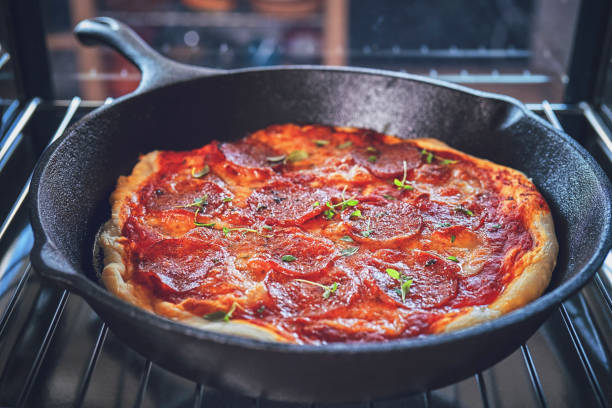 istock Preparing Pan Pizza with Salami in Domestic Kitchen 1076812782